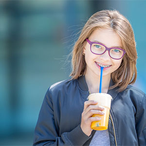 preteen girl with braces holding drink