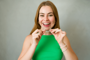 Patient holding clear aligners during Invisalign treatment in Gurnee, IL