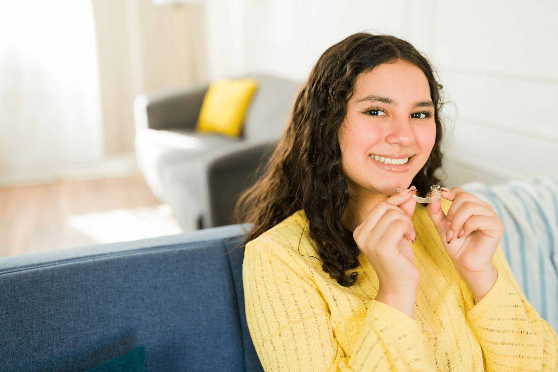 Teen holding clear aligners while learning what can speed up orthodontic treatment in Gurnee IL