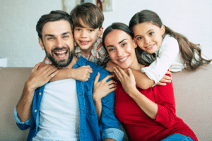 Smiling family of four sitting close together on a couch